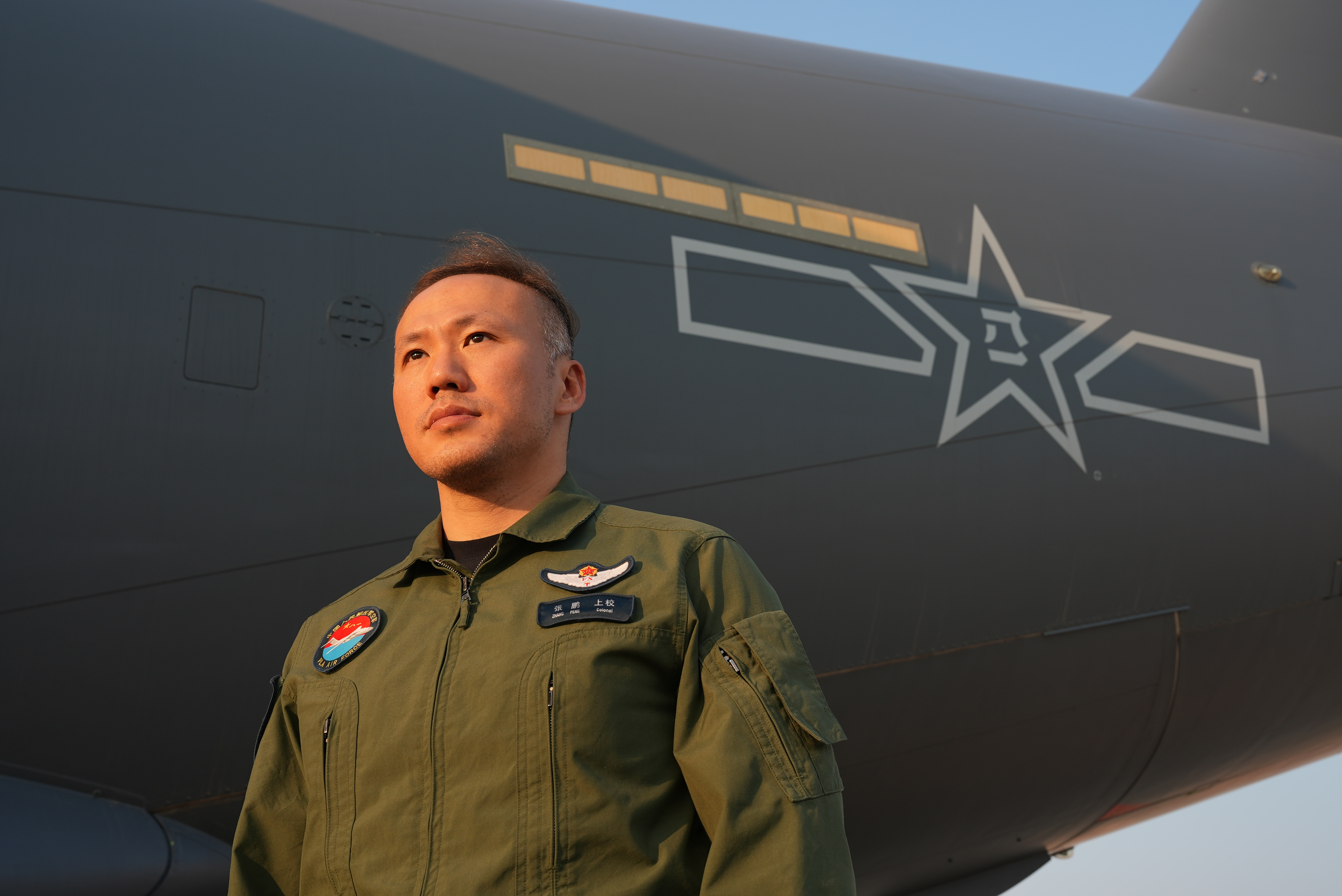 Zhang Peng, Y-20 captain and flight instructor, stands under the wing of the aircraft. /PLA Air Force