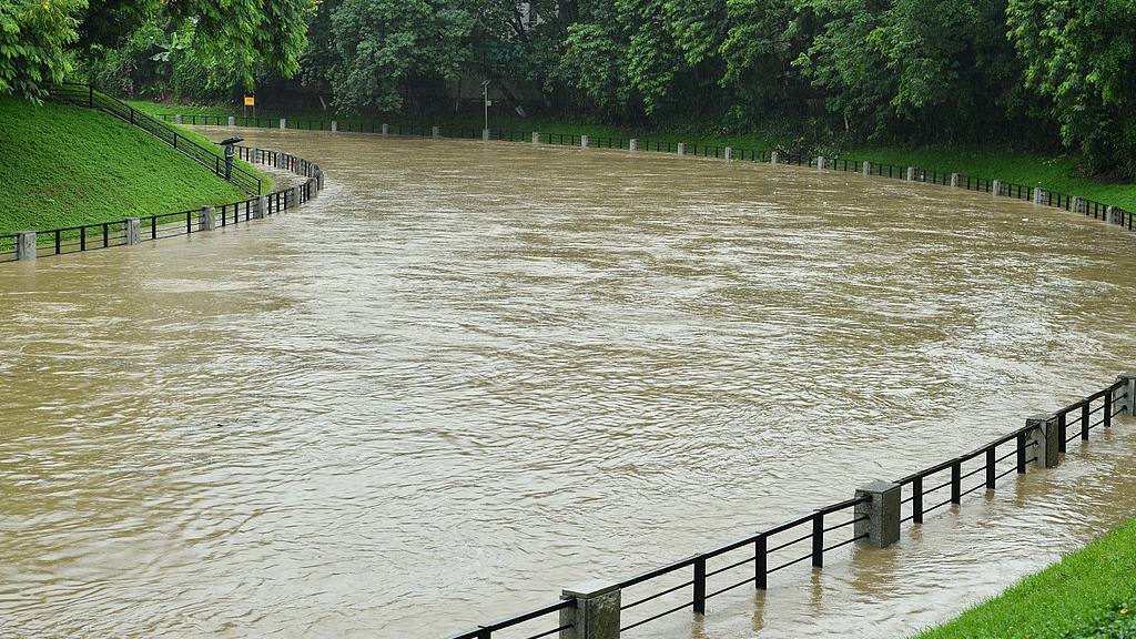 A staff check the situation of a local river amid heavy rain in Tianhe District, Guangzhou City, Guangdong Province, June 28, 2026. /VCG 