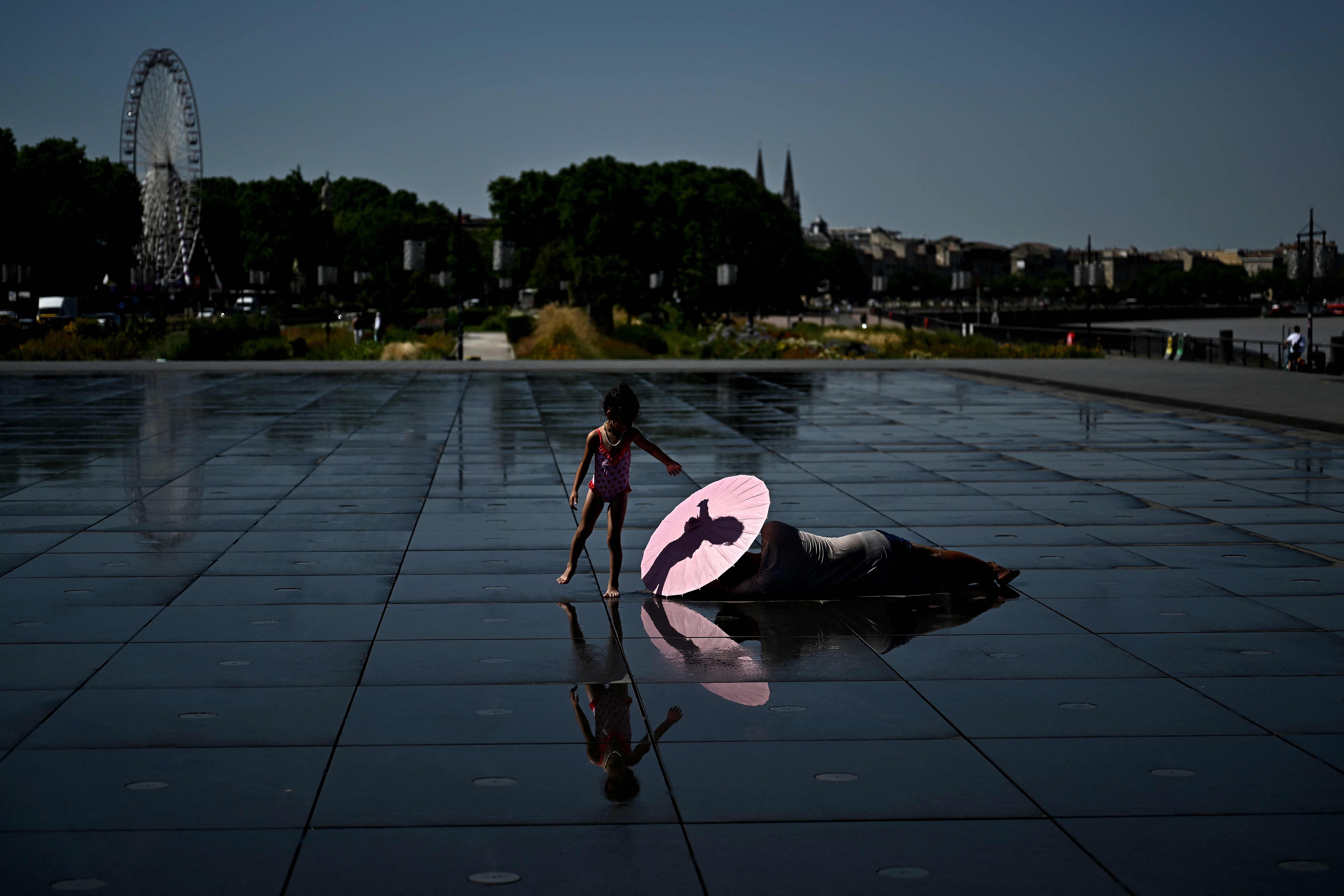 A girl cools off in the Miroir d'Eau reflecting pool during a heatwave in Bordeaux, France, June 23, 2026. /VCG