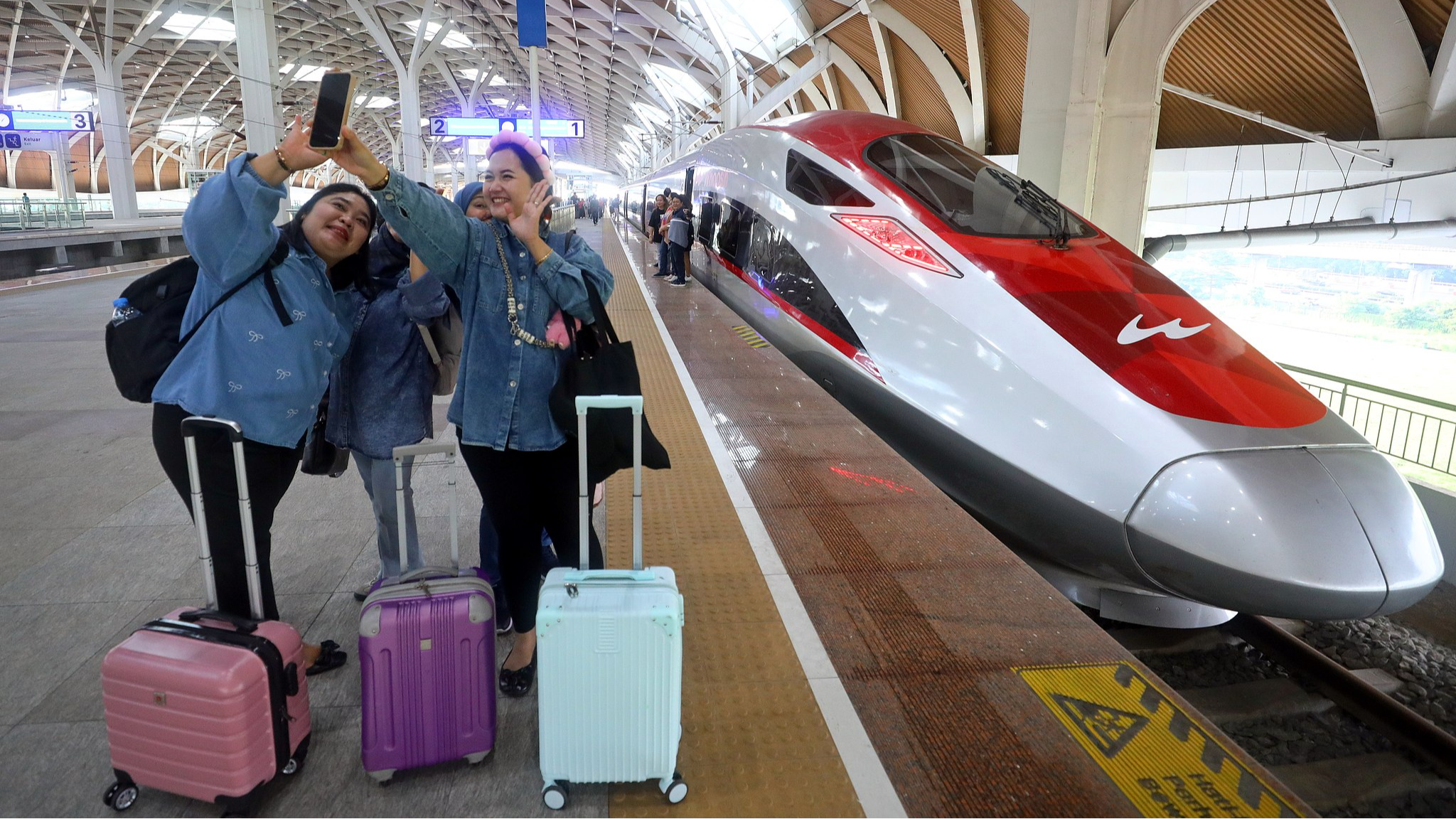 Passengers pose for photos with a train at Halim Station in Jakarta, Indonesia, a complex serving the Jakarta-Bandung High-Speed Railway, a flagship Belt and Road cooperation project between China and Indonesia, May 24, 2025. /CFP