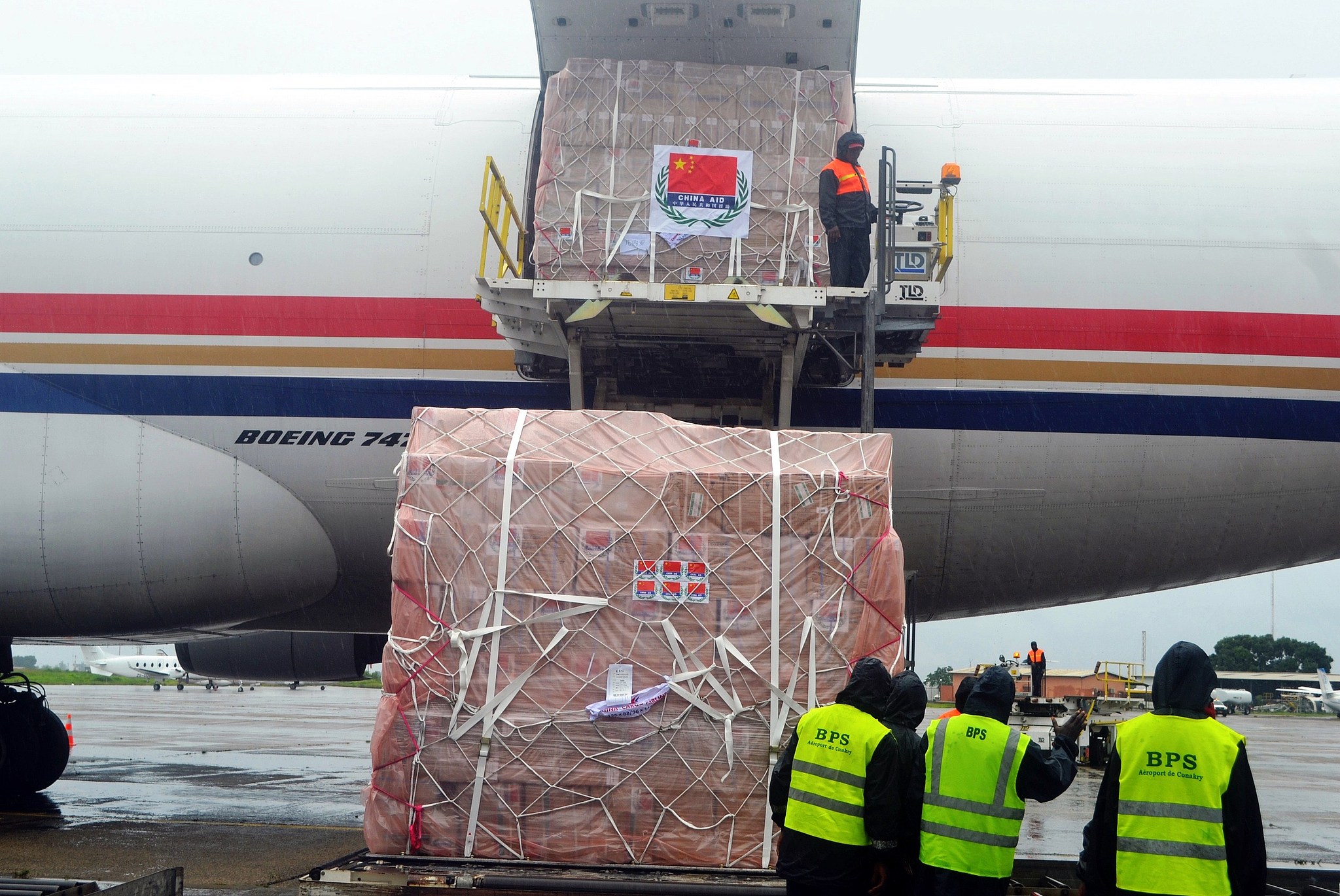 Workers unload medical supplies from China for countries hit by the Ebola outbreak from an airplane at the Conakry International Airport, Guinea, August 11, 2014. /VCG 