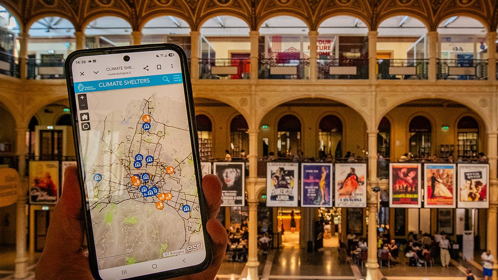 A mobile phone displays Bologna's climate shelter map in front of Biblioteca Salaborsa during the heatwave in Bologna, Italy, June 29, 2026. /VCG
