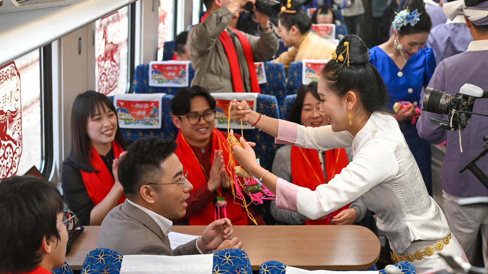 Performers present ornaments to passengers as a Chinese New Year's blessing on the China-Laos Railway international passenger train, February 4, 2026. /CFP