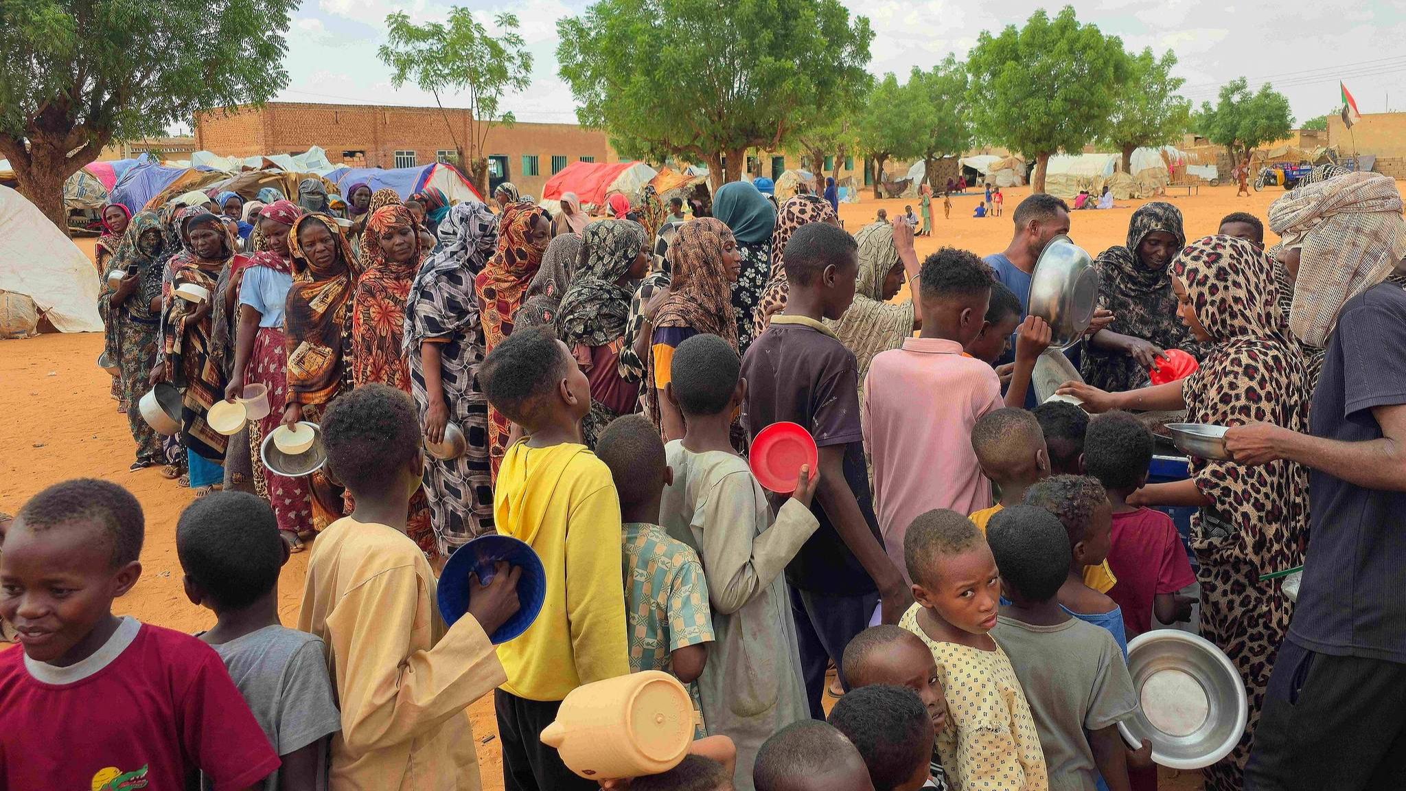Women and children queue to receive free food being distributed in al-Mohayra camp for displaced people, near the city of El-Obeid in the southern Kordofan region, June 29, 2026. /VCG