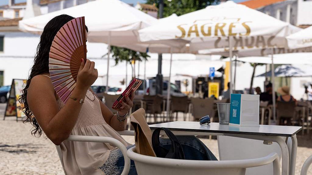 A woman uses a fan to cool off in Evora, Portugal, with temperatures nearing 40 degrees Celsius, July 1, 2026. /VCG