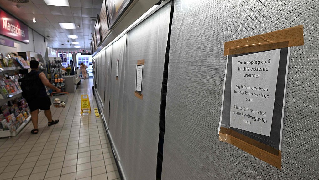 Signs on blinds covering fridges in the chilled food aisle of a supermarket alert customers that they have been pulled down to keep food cool during the extreme heat, Guildford, England, June 25, 2026. /VCG