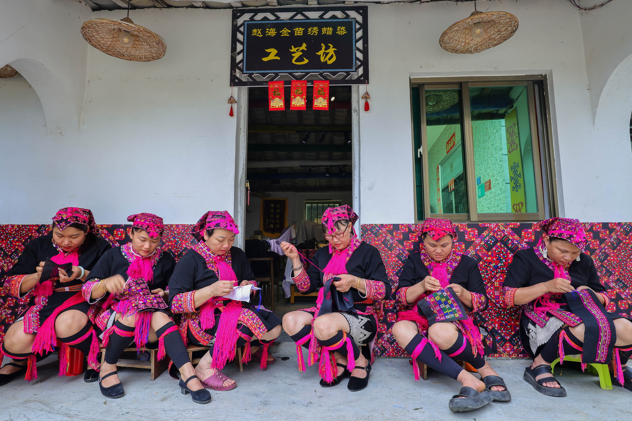 Inheritor Zhao Haijin, third from the right, and Miao embroidery learners are seen at Zhao's workshop in Hainan Province on July 1, 2026. /VCG