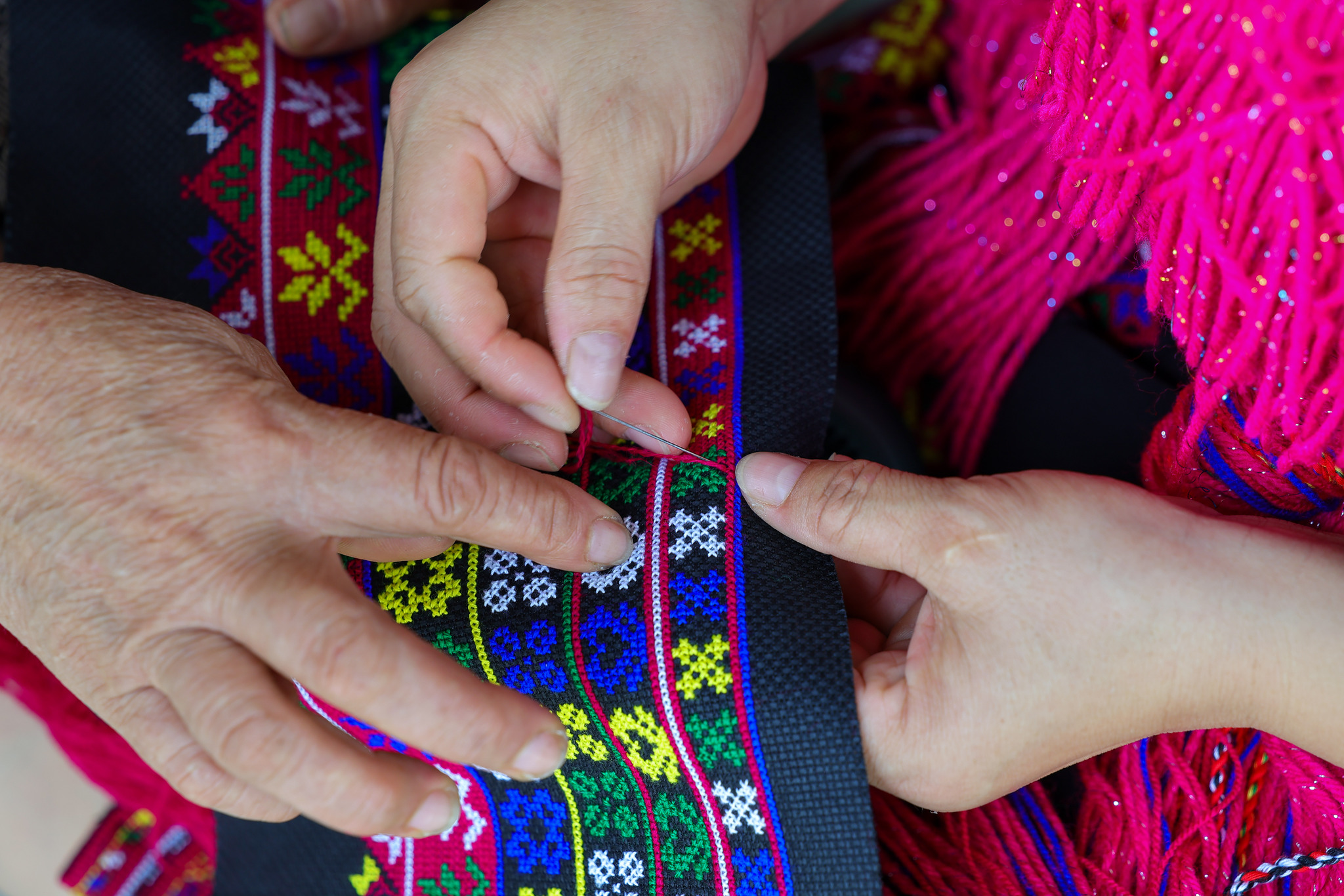 Inheritor Zhao Haijin guides Miao embroidery learners at her workshop in Hainan Province on July 1, 2026. /VCG