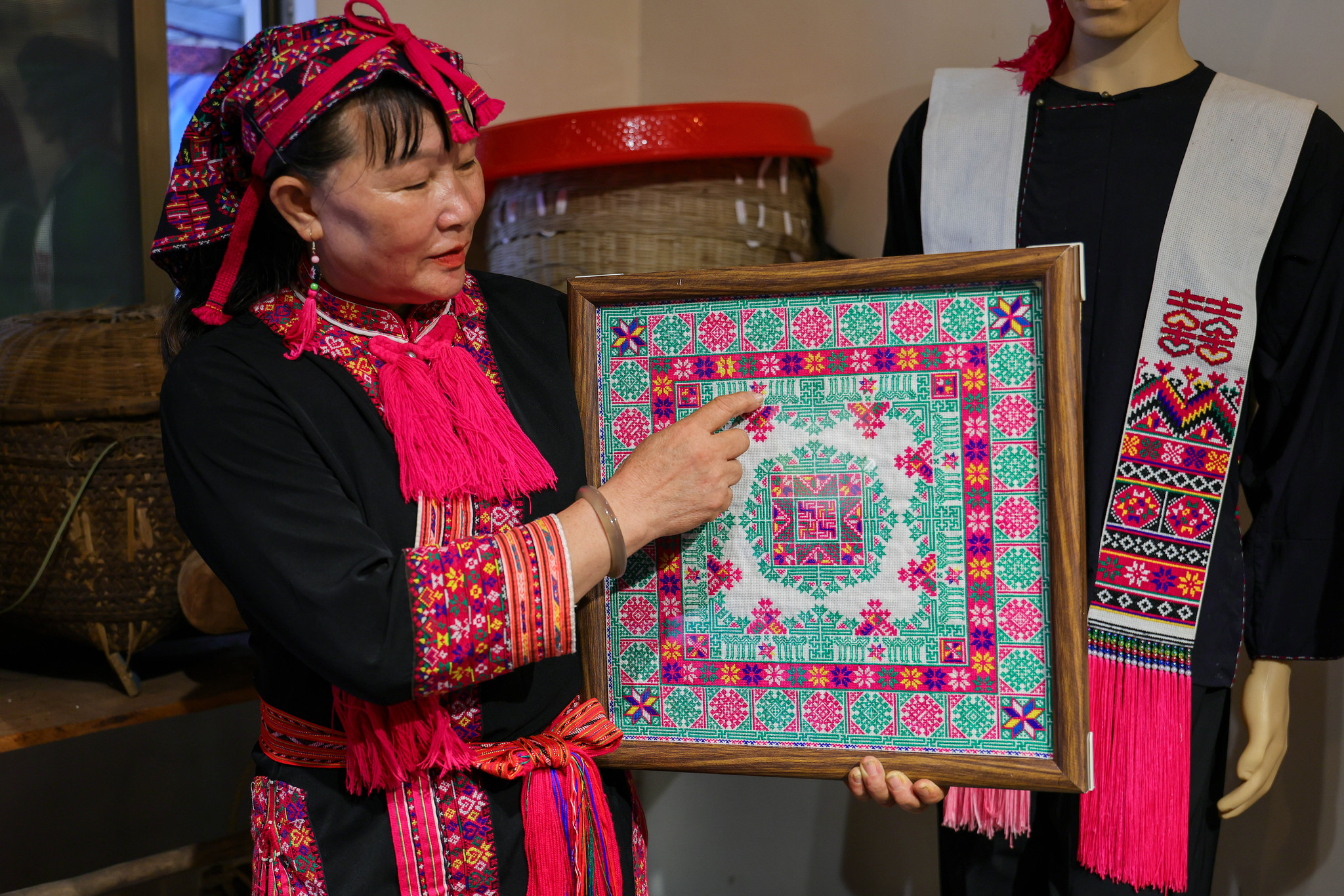 Inheritor Zhao Haijin shows her Miao embroidery piece, which was showcased at the 2020 China International Fashion Week, in Hainan Province on July 1, 2026. /VCG