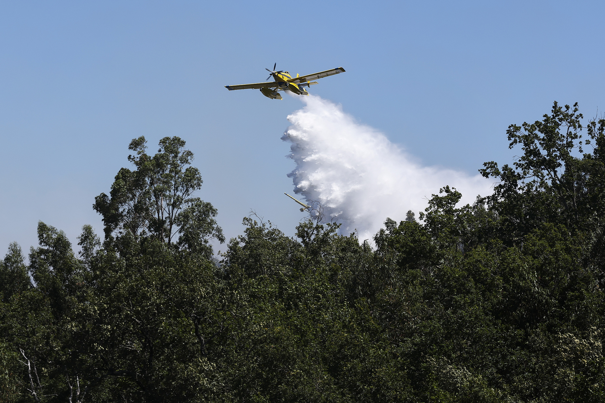 A firefighting plane drops water over a forest fire in Vouzela, Portugal, July 2, 2026. /VCG