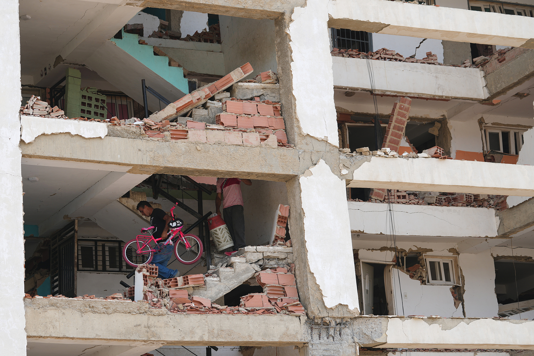 A man retrieves a bicycle from a building damaged in the earthquakes that struck La Guaira, Venezuela, July 2, 2026. /VCG
