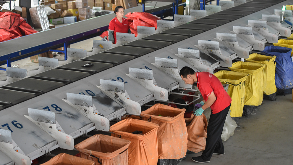 Workers pick delivery parcels in Qingzhou, Shandong Province, China, June 18, 2026. /VCG