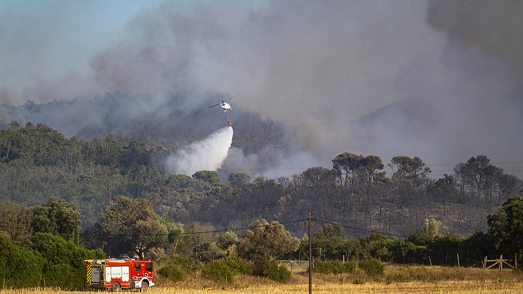 A helicopter carries water to contain flames as a wildfire tears through the ecologically sensitive Les Gavarres mountain range in the Baix Emporda district of Catalonia, Spain, July 3, 2026. /VCG