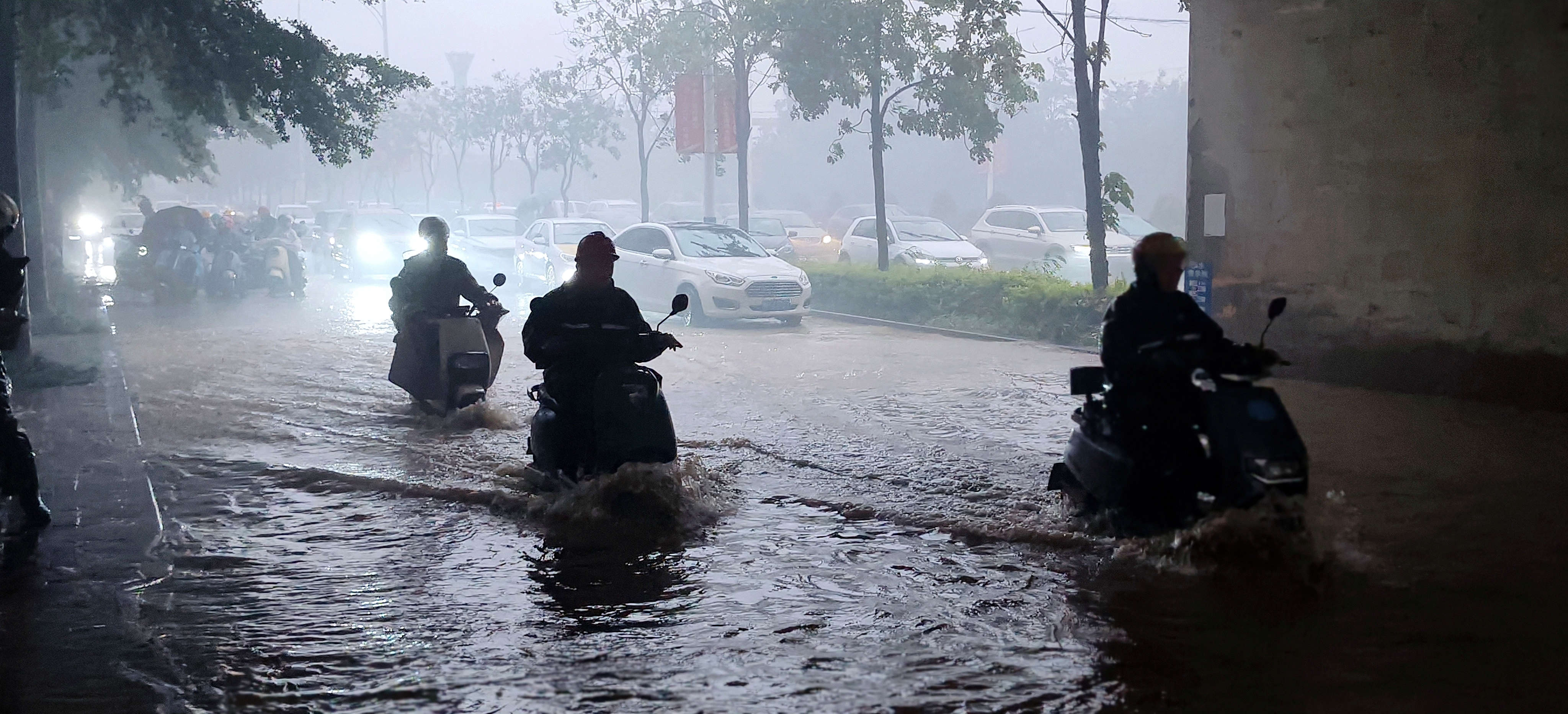 Vehicles make their way through floodwaters beneath a railway bridge in Fangchenggang, south China's Guangxi Zhuang Autonomous Region, July 5, 2026. /VCG