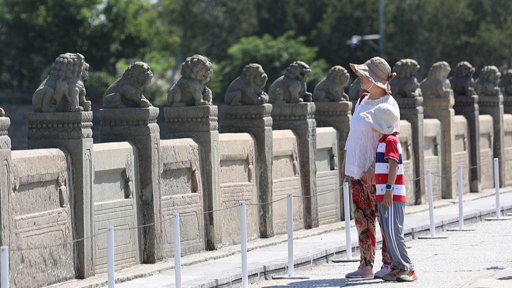 Visitors view the stone lion statues on the Lugou Bridge in Beijing, China, July 6, 2026. /VCG