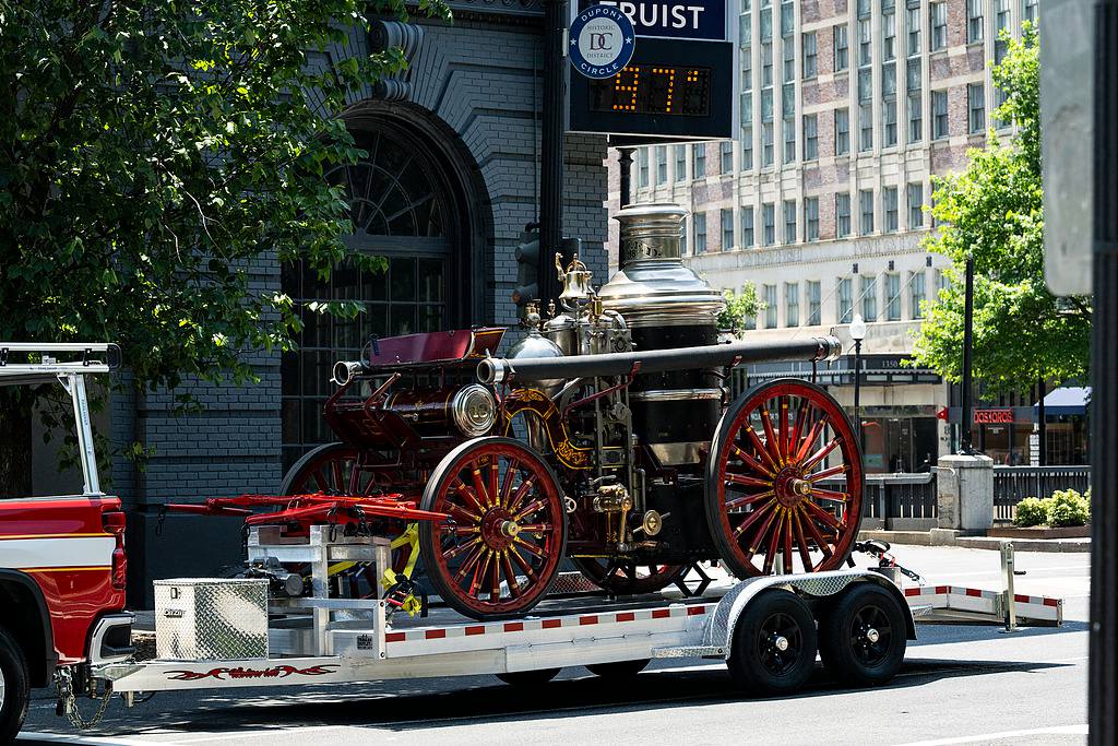An antique fire truck is towed past a digital thermometer reading 97 degrees Fahrenheit (about 36.1 degrees Celsius) amid extreme heat in Washington, DC, July 4, 2026. /VCG