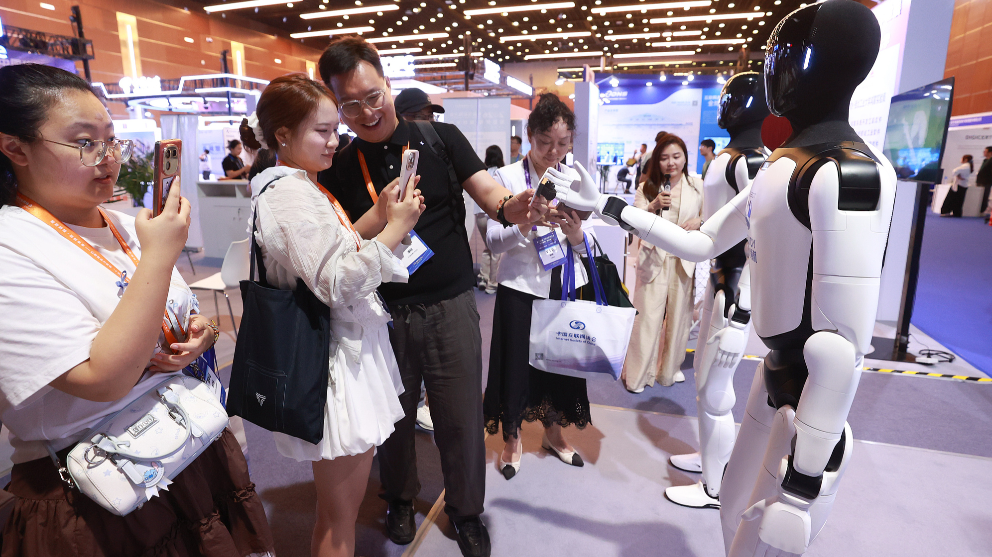 Participants of the 25th China Internet Conference interact with humanoid robots at the China National Convention Center in Beijing, capital of China, July 8, 2026. /VCG