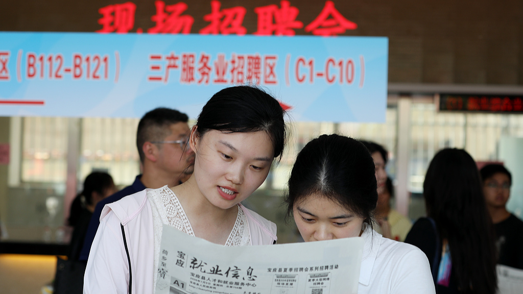 People look at employment information at a job fair in Baoying, Jiangsu Province, China, July 9, 2026. /VCG