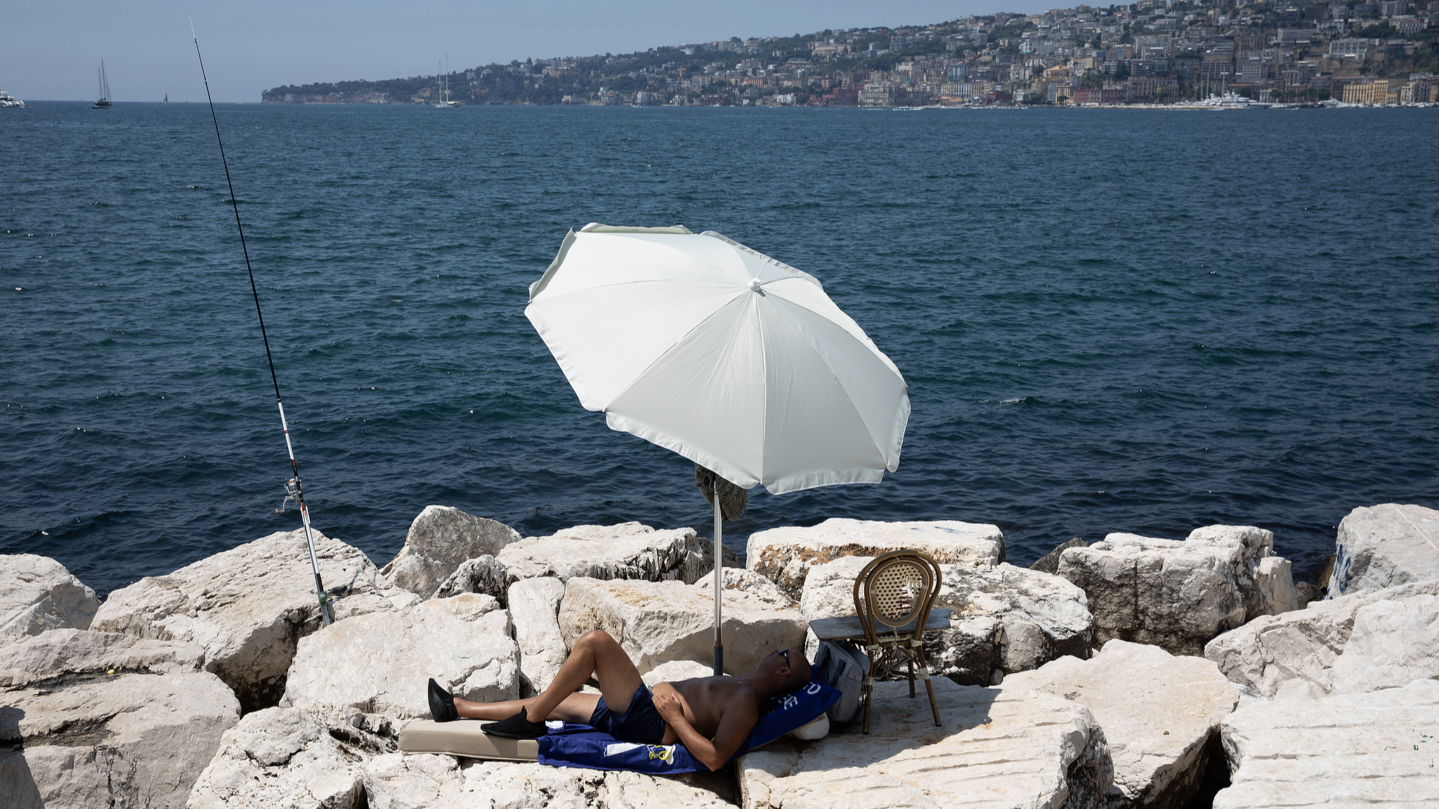 A man is seen during a warm morning near the seafront of Naples, Italy, July 7, 2026.  /VCG