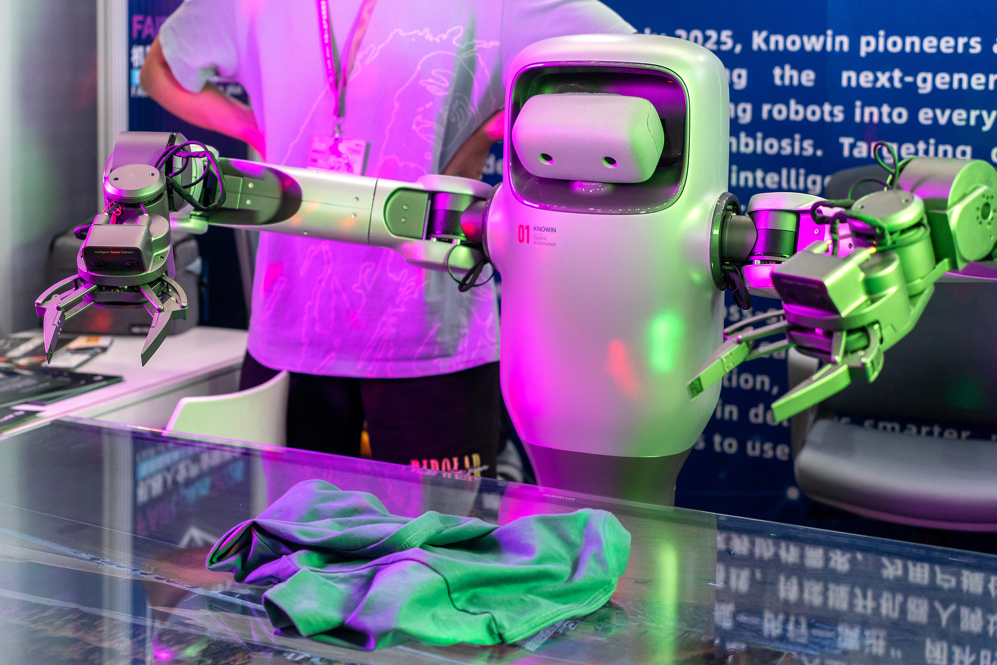 A humanoid robot demonstrates the process of folding clothes at the 2026 Robot Full Industry Link Conference in Shenzhen, China, April 22, 2026. /VCG