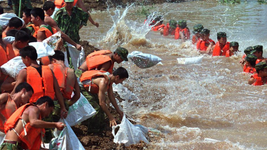 PLA soldiers reinforce a levee against floodwaters in Hubei Province, central China, during the country's historic 1998 floods. (Xinhua)