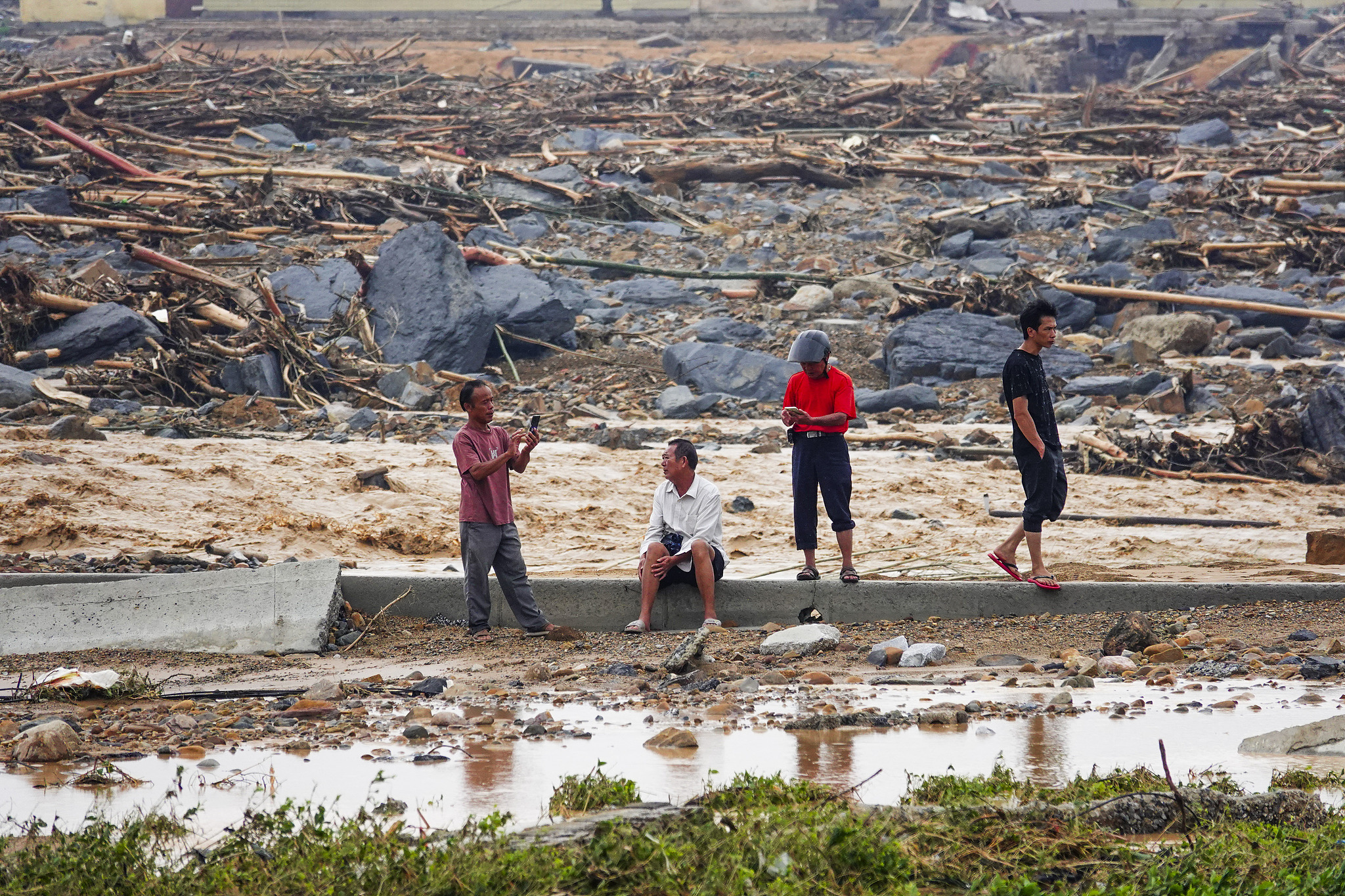 Local residents are seen near the debris after flooding hit Liulan Village, Nanning City, Guangxi Zhuang Autonomous Region, south China, July 8, 2026. /CFP