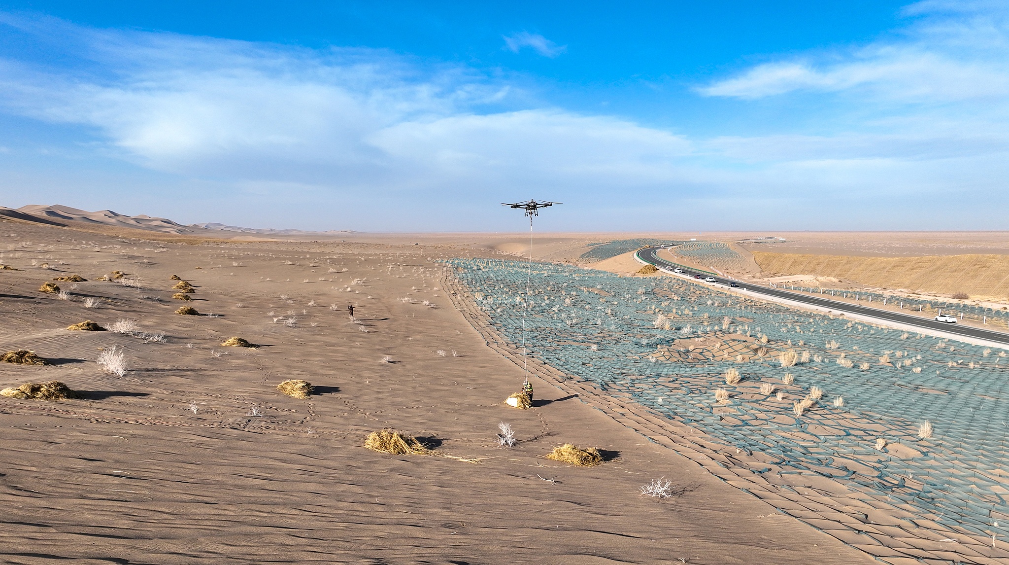 File photo of drones airlift straw deep into the desert in Jiuquan, Gansu, to combat desertification. /VCG