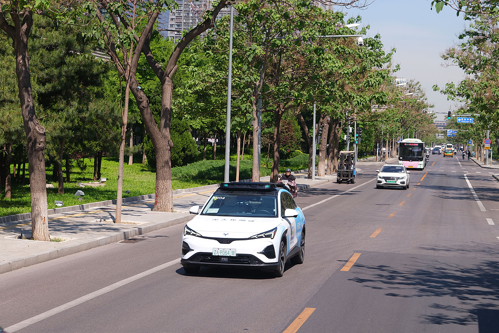 Passengers take a ride in a self-driving vehicle in Beijing E-Town's autonomous driving demonstration zone, May 8, 2026. /VCG