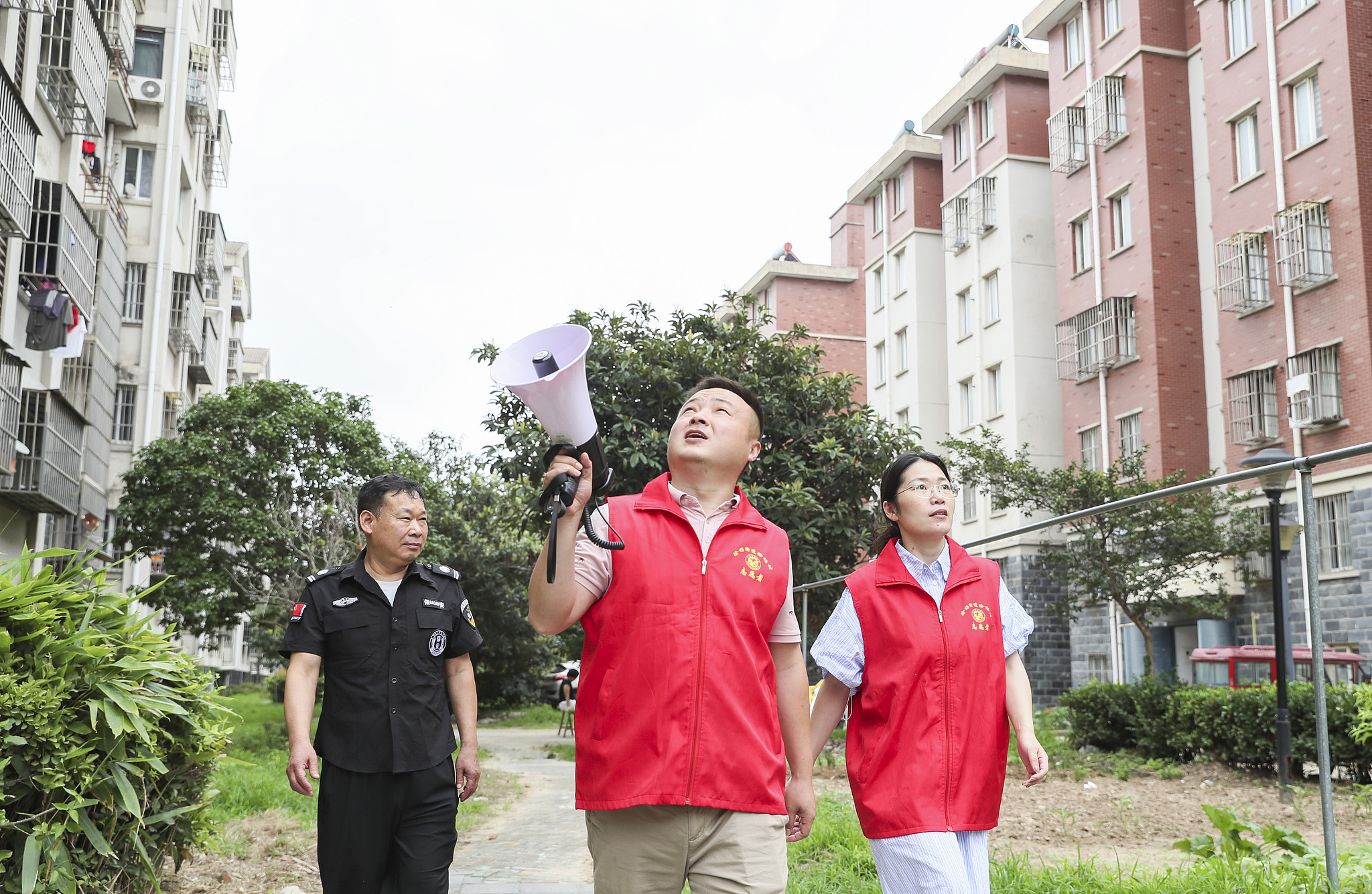 Volunteers and property management staff remind residents of typhoon safety precautions in Huai'an, east China's Jiangsu Province, July 12, 2026. /VCG