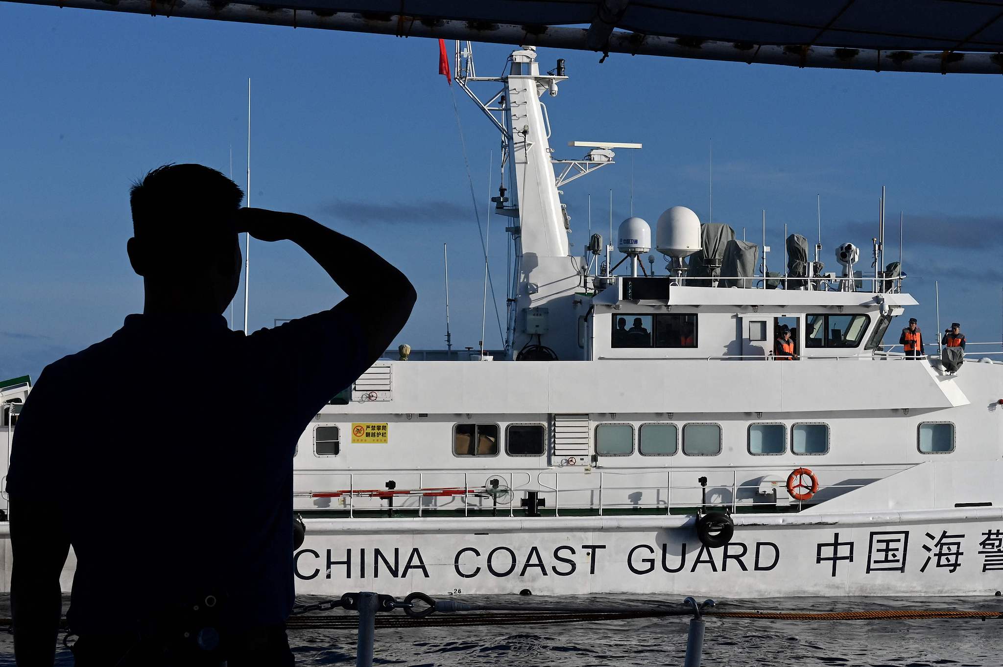A man looks at a China Coast Guard vessel in the South China Sea, November 10, 2023. /VCG