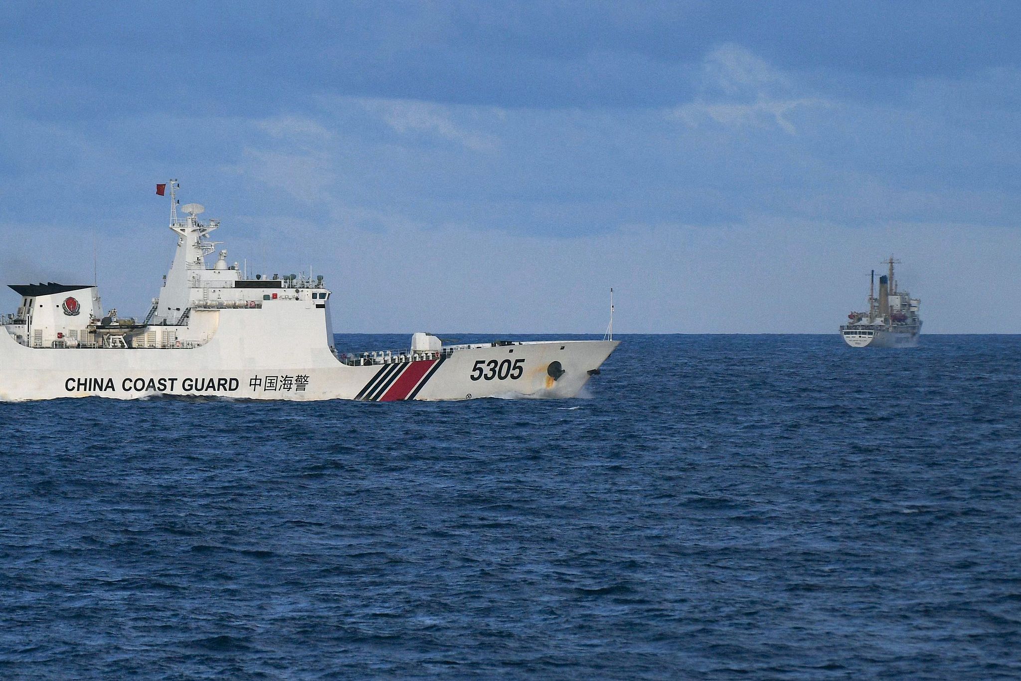 A China Coast Guard ship (L) sails near a Philippine vessel in the South China Sea, December 10, 2023. /VCG