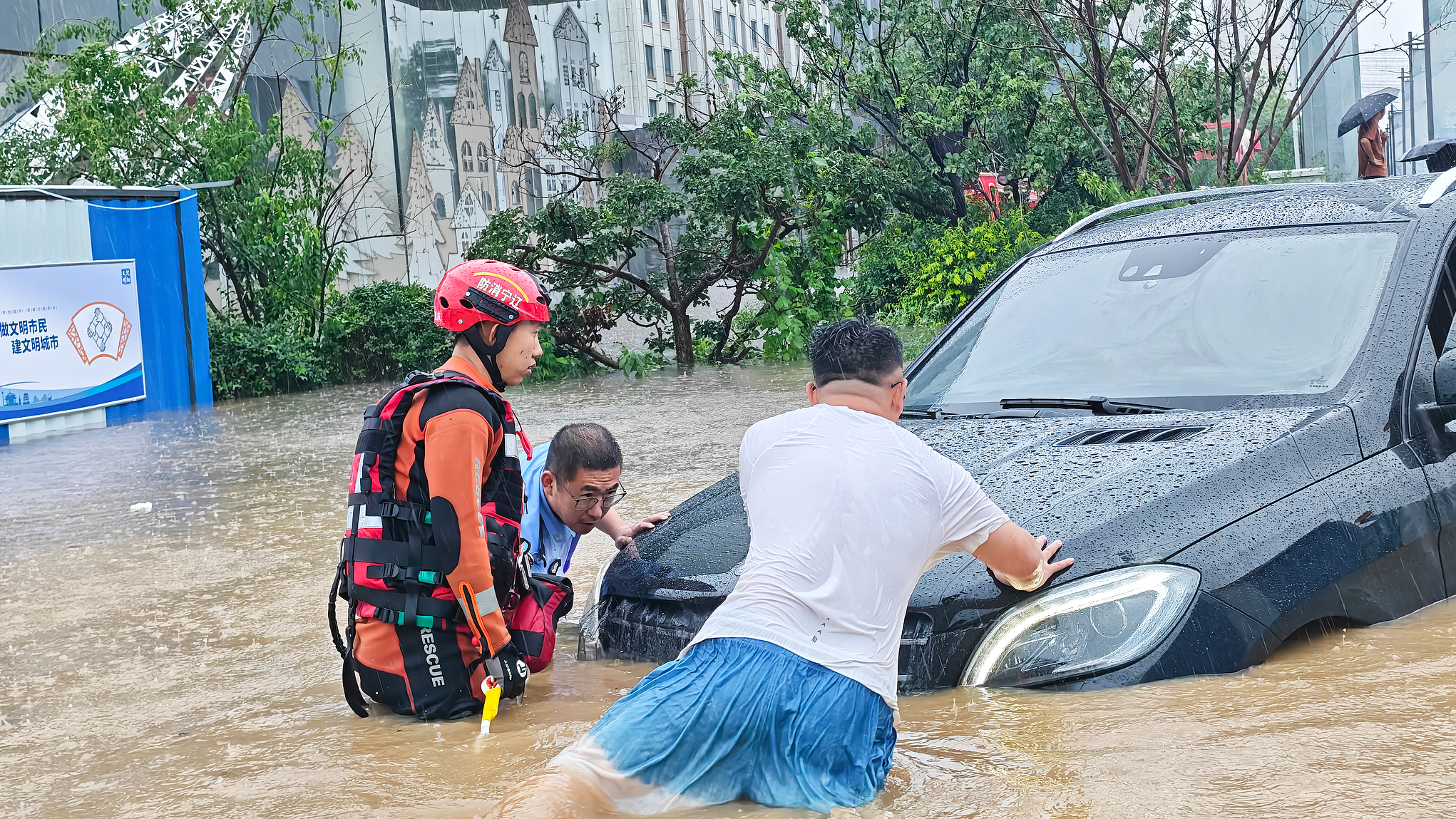 Police officers assist stranded residents and vehicles on a severely flooded road in Huanggu District, Shenyang, northeast China's Liaoning Province, July 13, 2026. /VCG