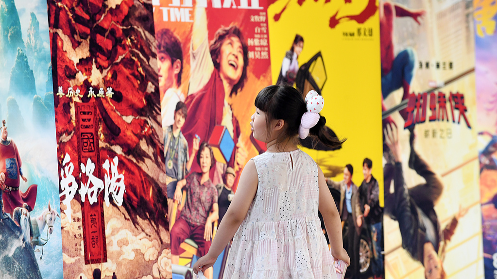 A girl passes by movie posters on display at a cinema in Zunyi, southwest China's Guizhou Province on July 12, 2026. /VCG