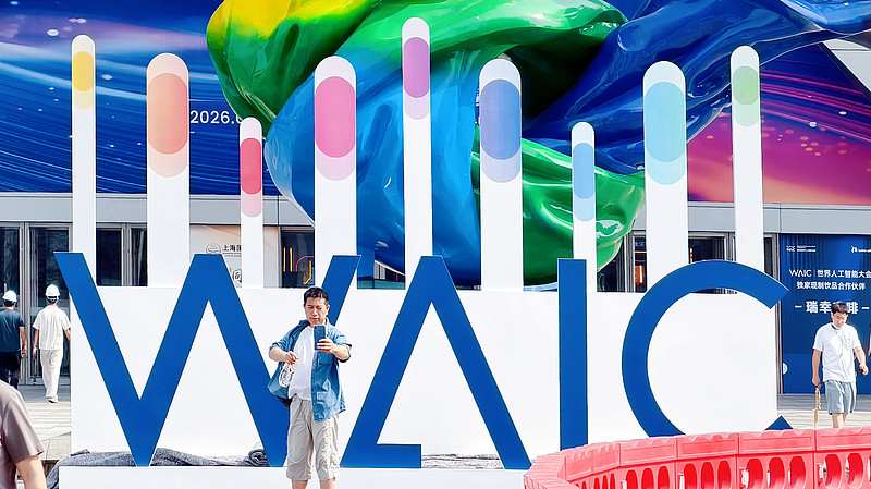 People take selfie in front of WAIC logo, Shanghai, July 14, 2026. /CFP