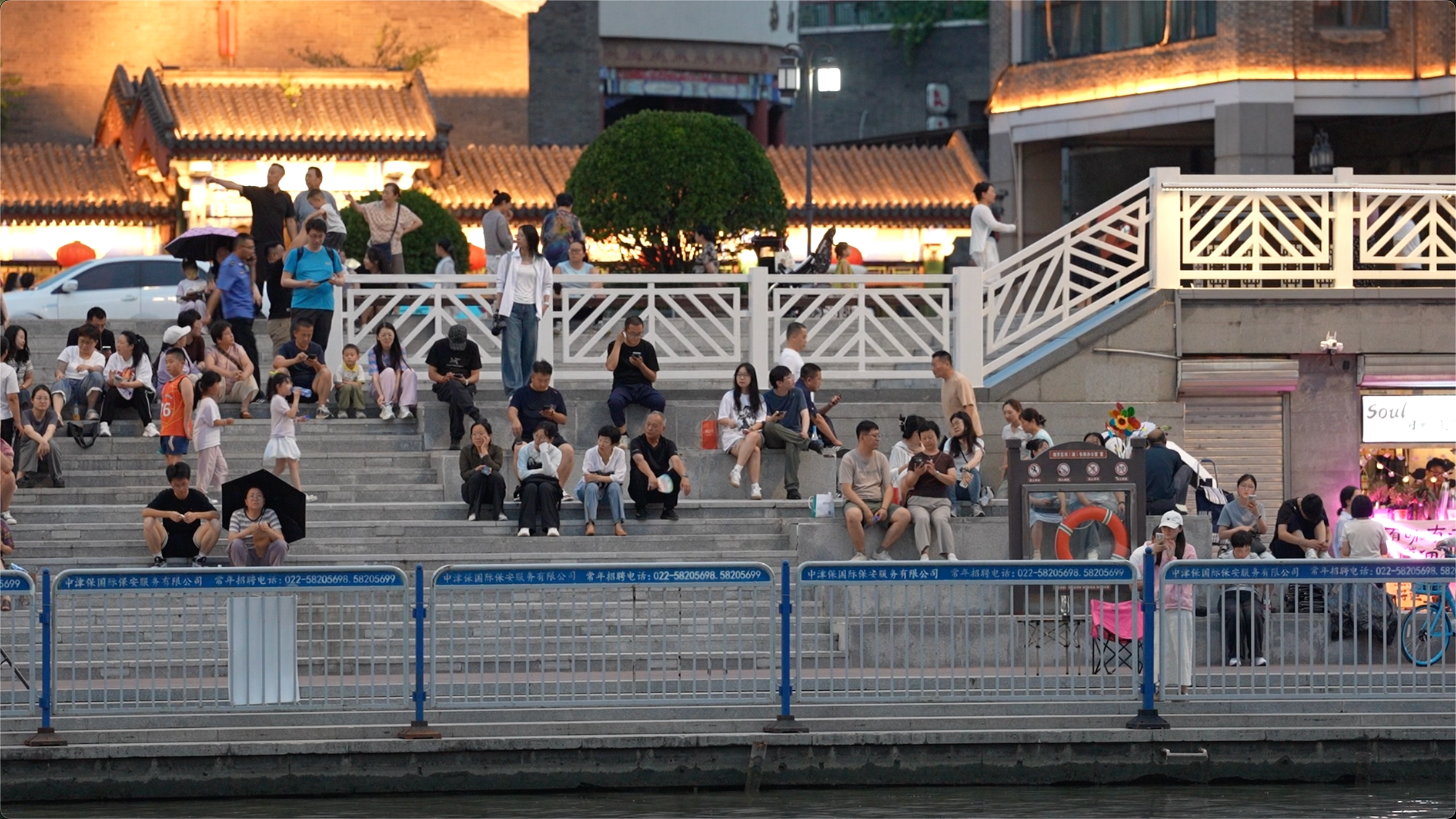 Many people sit by the Haihe River to enjoy the evening breeze in Tianjin, northern China on July 9, 2026. /CGTN