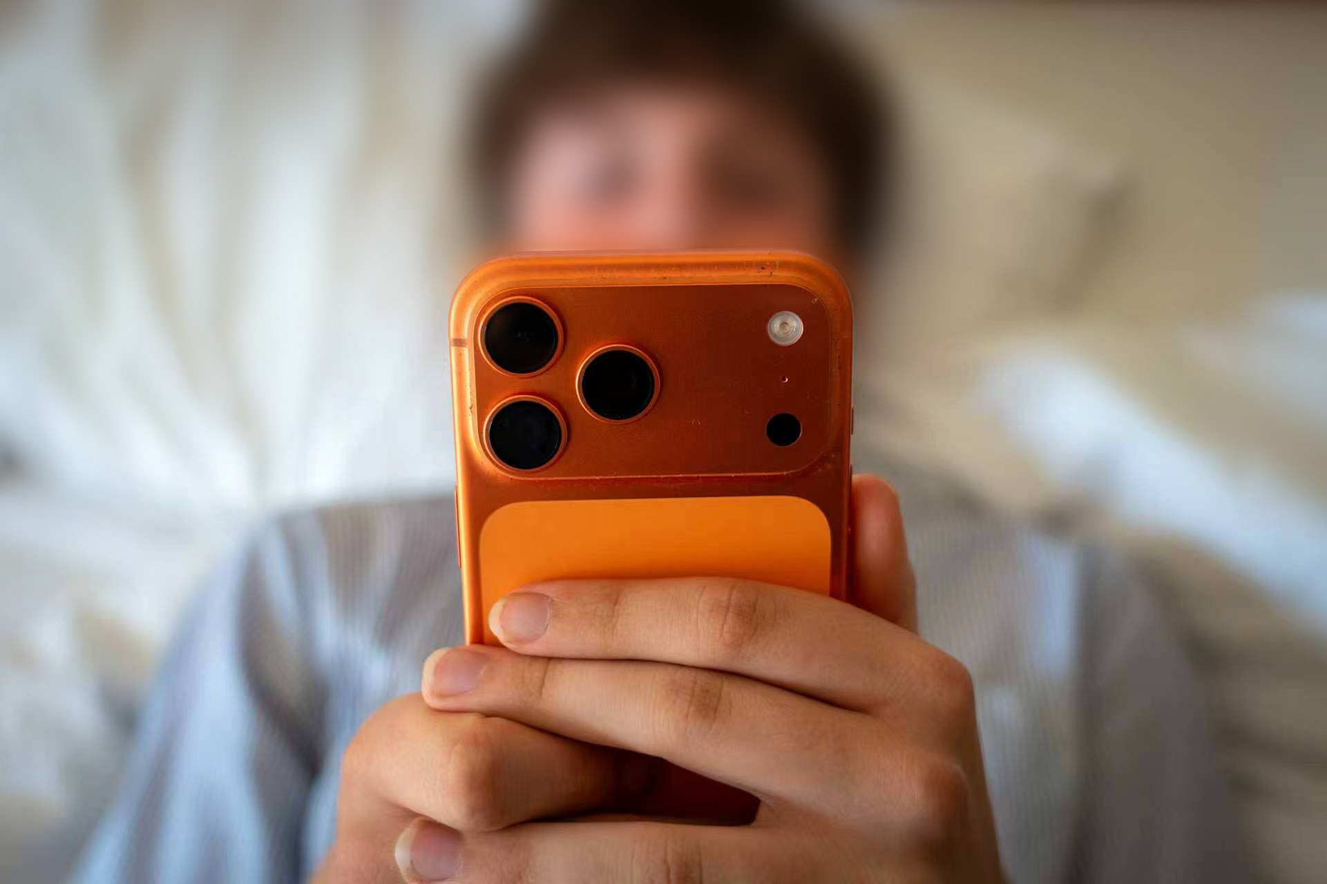 A teenage boy looks at his smartphone screen in his bedroom in Somerset, the UK, July 1, 2026. /VCG