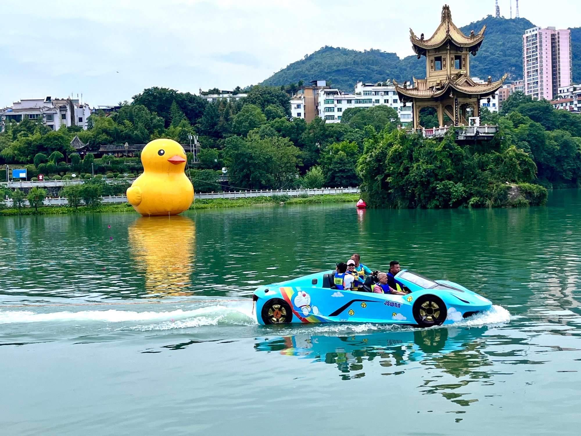 Tourists take a boat down the Jinjiang River in Tongren, southwest China's Guizhou Province in July 2026. /Tongren Media Convergence Center