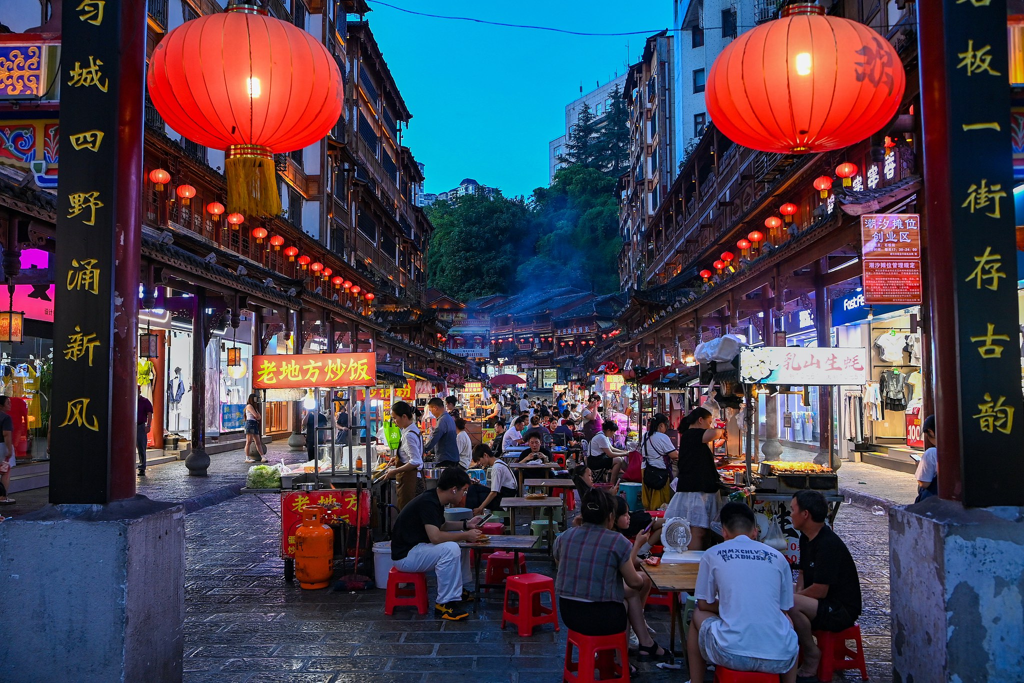 Tourists sample local snacks on a stone-paved street at night, Duyun, southwest China's Guizhou Province, July 12, 2026. /VCG