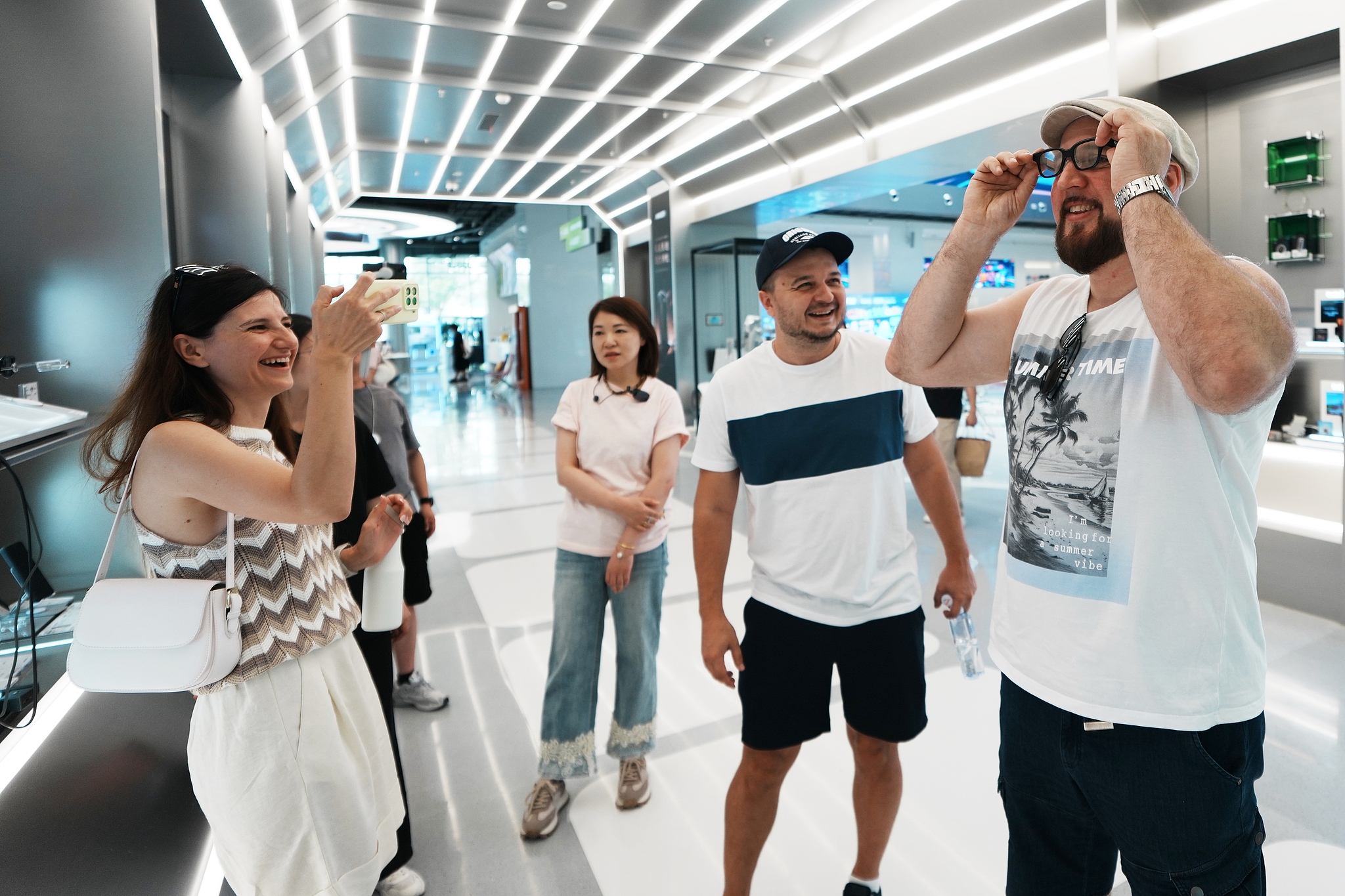 Foreign visitors try on AI glasses at the WAIC on July 17, 2026, in Shanghai, China. /VCG