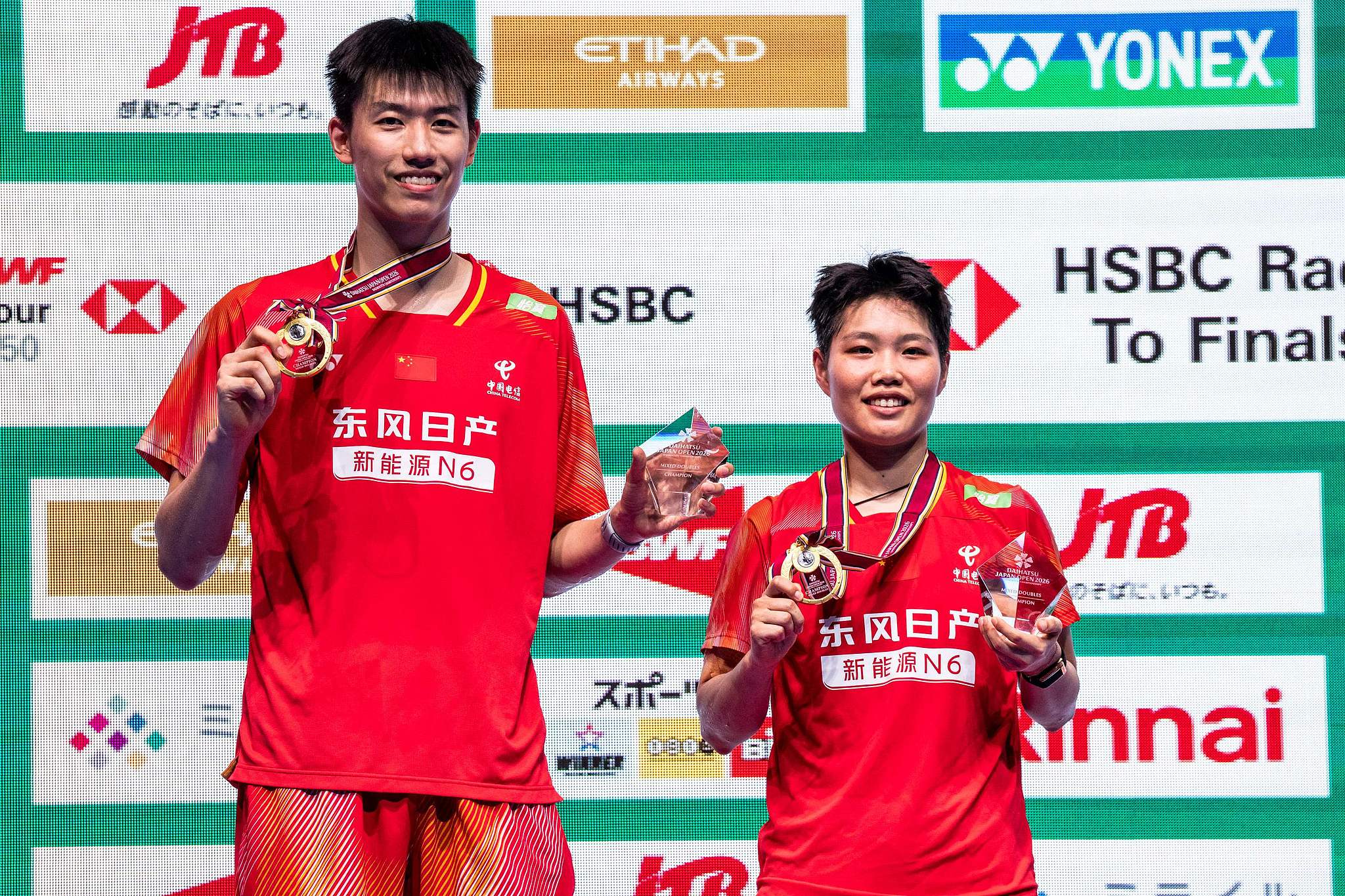 China's Feng Yanzhe (L) and Huang Dongping display their awards after defeating Tang Chun Man and Tse Ying Suet from China's Hong Kong SAR (Special Administrative Region) in the mixed doubles final at the BWF Japan Open in Tokyo, Japan, July 19, 2026. /VCG