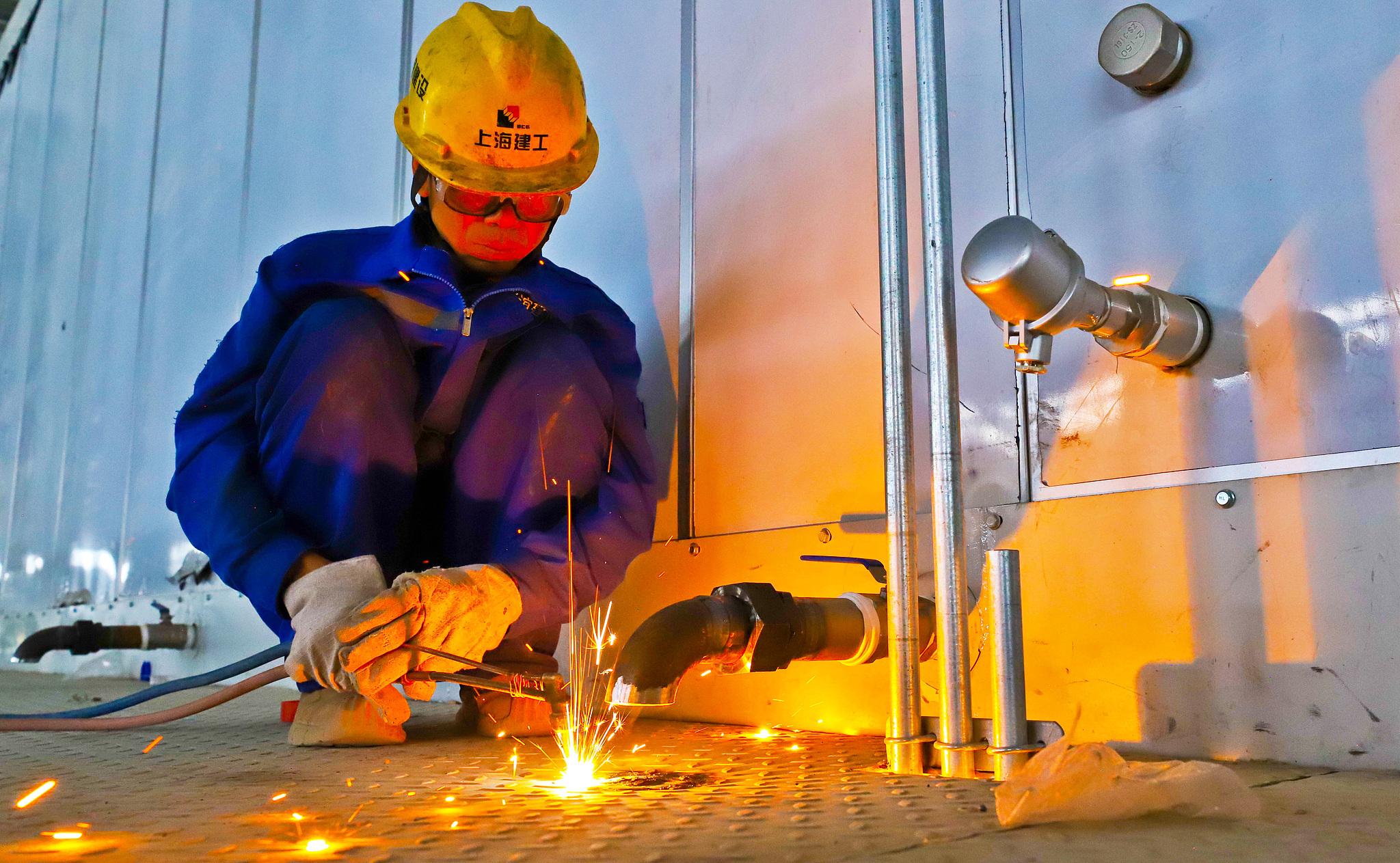 A construction worker welds pipeline supports under high temperatures at the construction site in Zhangye, Gansu Province, China, July 8, 2026. /VCG 