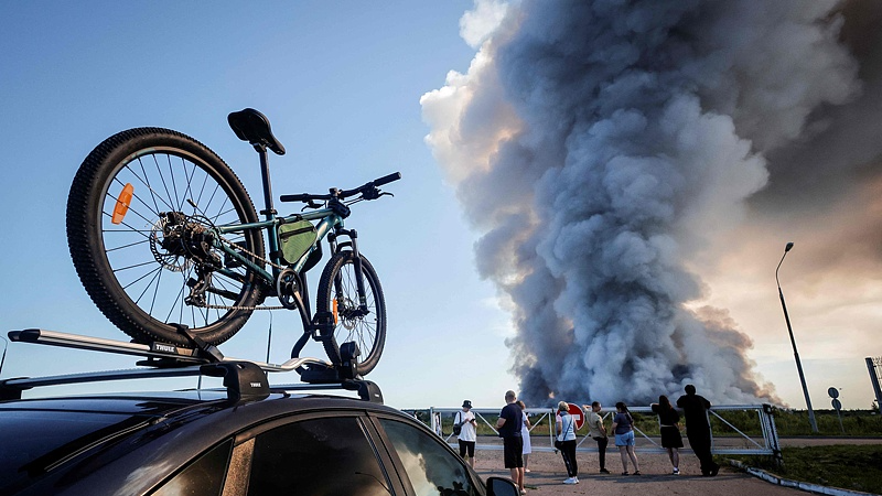 Bystanders watch as smoke rises from a fire at the Russian e-commerce firm Wildberries' logistics complexes in the town of Elektrostal outside Moscow, Russia, July 18, 2026. /VCG