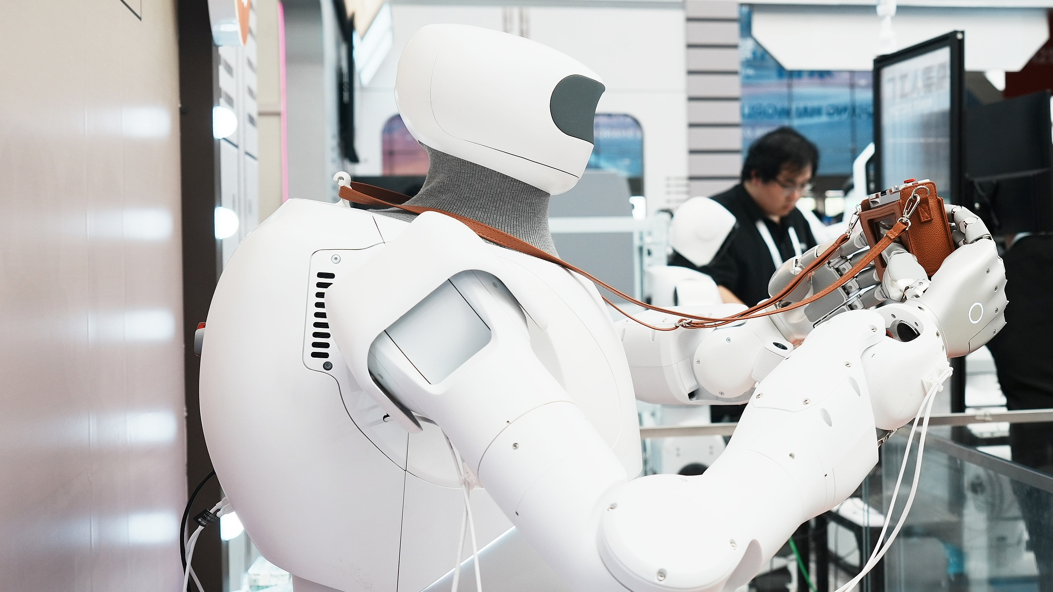 A humanoid robot snaps live photos for attendees during the World Artificial Intelligence Conference in Shanghai on July 17, 2026. /VCG