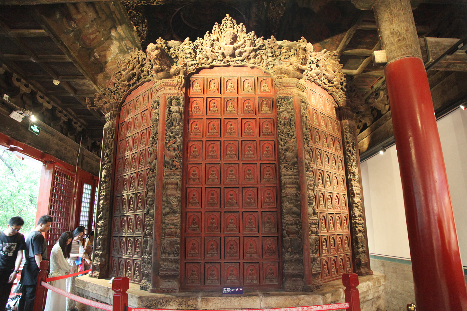 Visitors admire the Ming Dynasty wooden sutra cabinet at the Zhihua Temple in Beijing. /CGTN