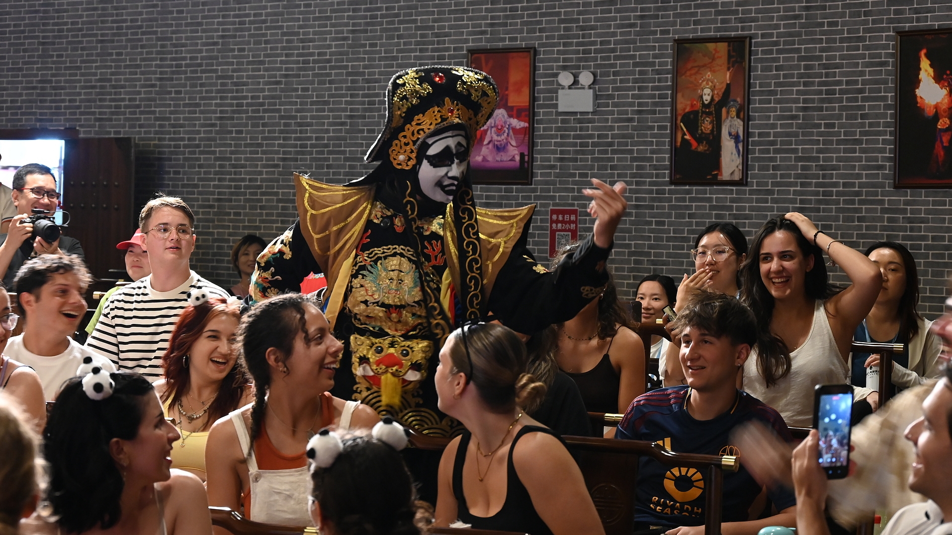 Foreign tourists watch a Sichuan Opera face-changing performance in Chengdu, southwest China's Sichuan Province, July 19, 2026. /VCG