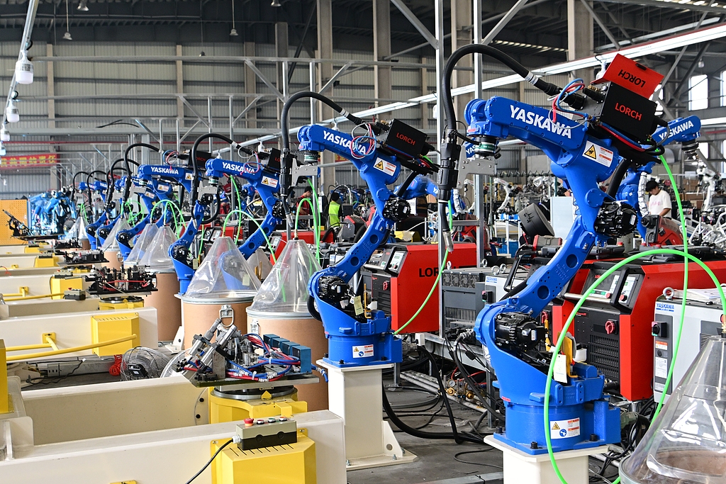 Industrial robots collaborate on cutting and welding in a smart workshop in Taicang, Jiangsu Province, China, on July 21, 2026. /VCG