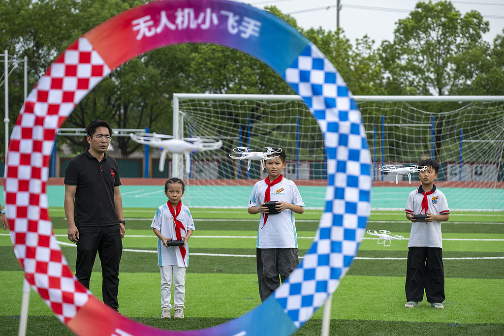Students learn drone piloting techniques under a teacher's guidance at a village primary school in Wuhu, Anhui Province, east China, September 11, 2025. /VCG