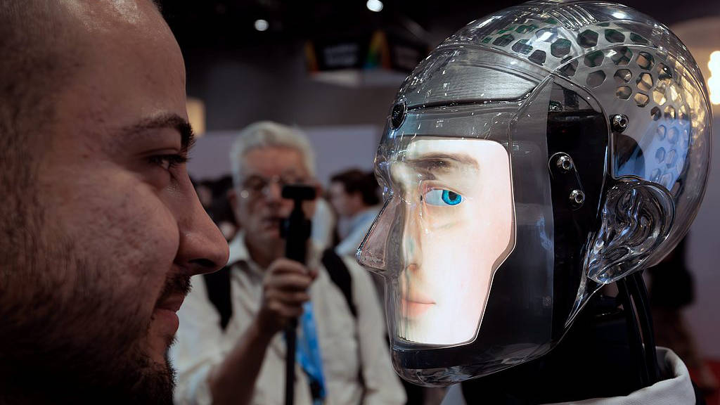 A visitor interacting with a robot at the AI for Good Global Summit in Geneva, July 7, 2026. /VCG