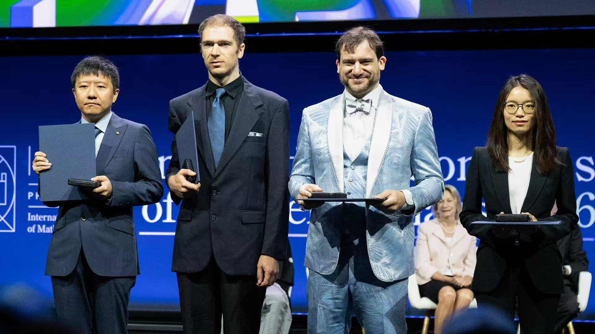 Four Fields Medal laureates pose for photos onstage after receiving their Fields Medals during the International Congress of Mathematicians in Philadelphia, July 23, 2026. /VCG