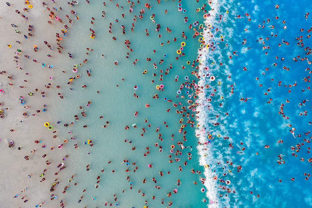 An aerial photo shows visitors enjoying waves in an artificial wave pool at a water park in Zhengzhou, Henan Province on July 22, 2026. /VCG